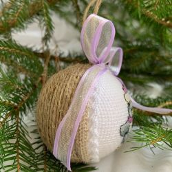 Weihnachtskugel mit aufgesticktem kleinen Pinguin.
