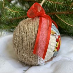 Weihnachtskugel mit gesticktem kleines Mädchen mit einem Weihnachtsbaum